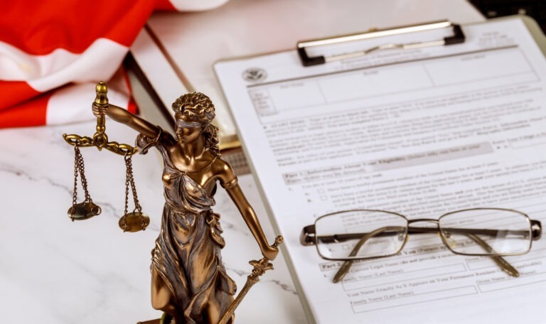 A statue justice with administration documents folders standing on lawyer's desk is depicted by the law