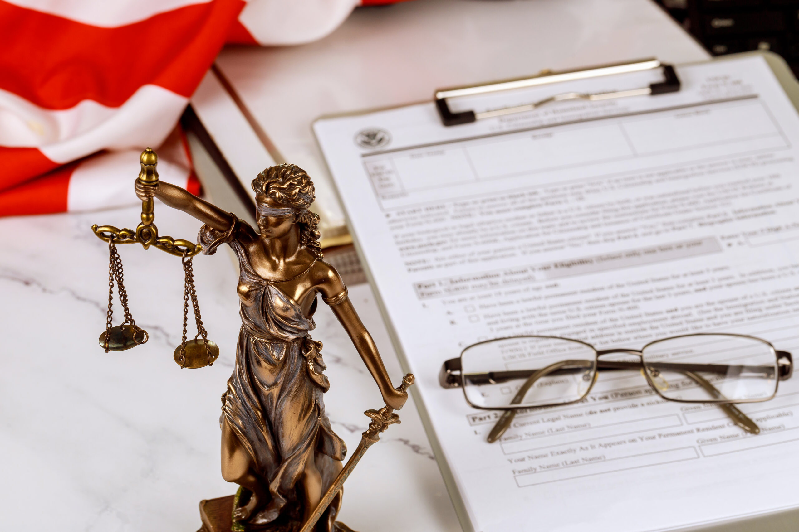 A statue justice with administration documents folders standing on lawyer's desk is depicted by the law